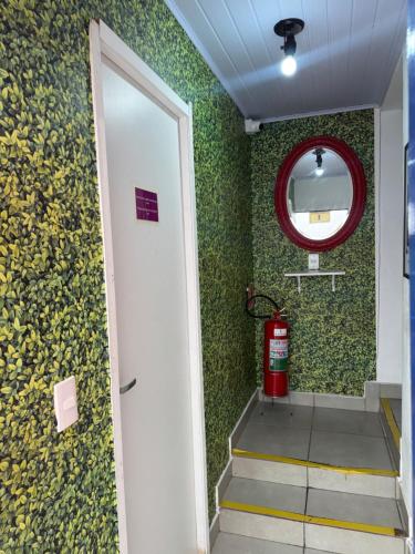 a room with a stairwell with a mirror and a fire extinguisher at Pinheiros Hostel & Food in São Paulo