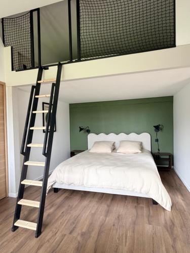 a bedroom with a bunk bed with a ladder next to it at Sillage in Machiel