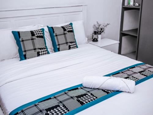 a bed with black and white pillows on it at Homes By Vee in Eldoret