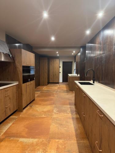 a large kitchen with wooden cabinets and a long hallway at Masia de Can Roig in Riells