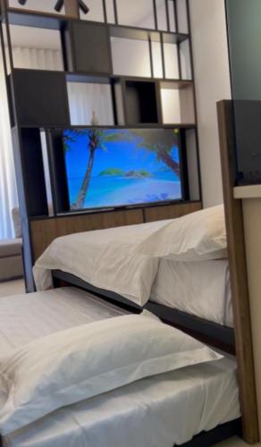 a bedroom with two beds and a flat screen tv at aura alraha village in Aqaba