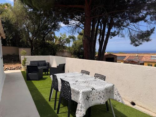 a white table and chairs on a lawn with a wall at casa serena in Lumio