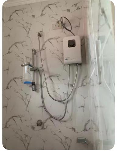 a shower in a bathroom with a white marble wall at Nenita in Baybay