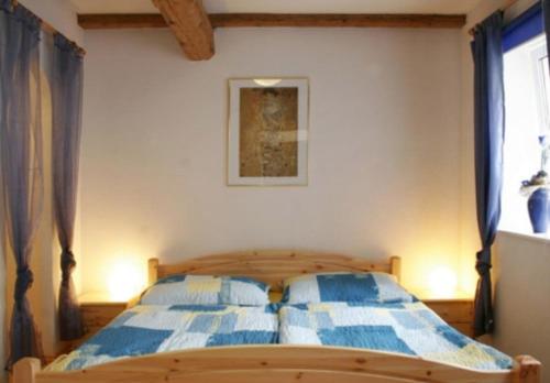 a bedroom with a bed with blue and white sheets at Ferienhaus Schmidlhof in Oggau