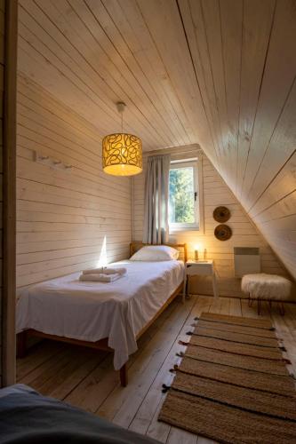 a bedroom with a bed and a chandelier at Zlatar Zen Chalet in Vukovina