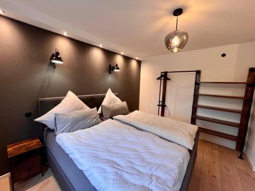 a bedroom with a bed with white sheets at Ferienhaus Kropsbach in Sankt Martin