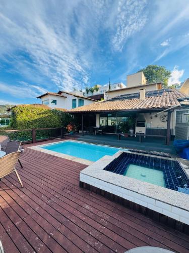 a backyard with a swimming pool and a house at Casa Brisa Escarpas in Capitólio
