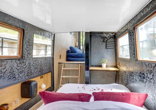 a bedroom with two beds and a table and two windows at Love Room sur l'eau & Rooftop in Asnières-sur-Seine
