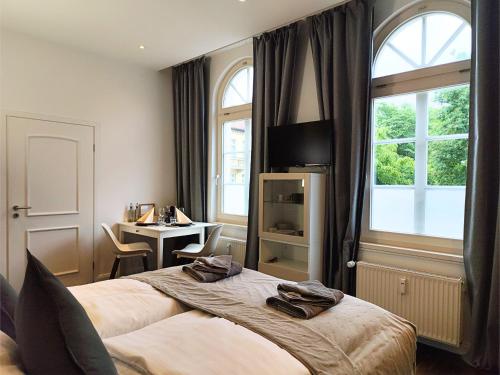 a bedroom with a bed and a desk and a window at ApartZ - Celle - CityQuartier - bis 15 Personen - 4 Apartments in Celle