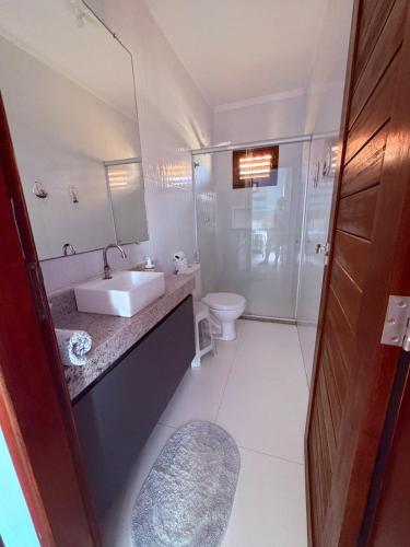 a white bathroom with a sink and a toilet at Maruá - Brisa e Sossego em Touros in Touros