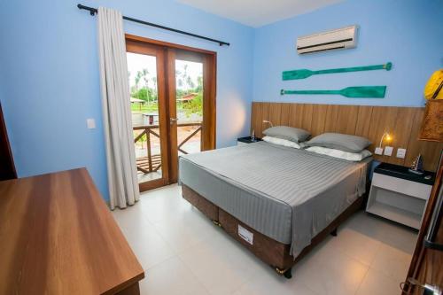 a blue bedroom with a bed and a balcony at Maruá - Brisa e Sossego em Touros in Touros