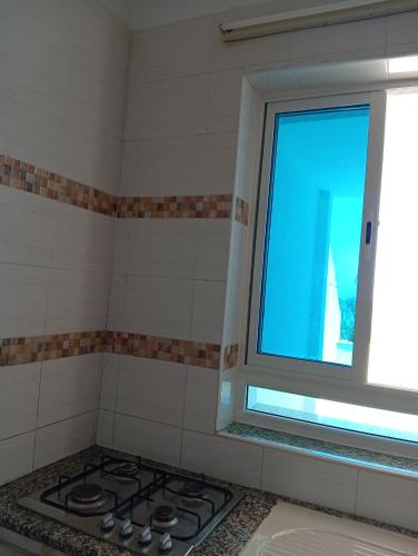 a kitchen with a stove and a window at B Résidence in Salakta