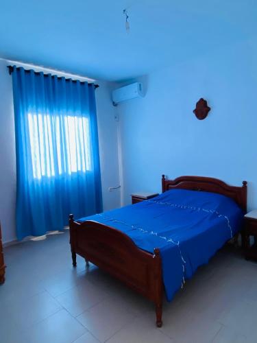 a bedroom with a bed with a blue light at B Résidence in Salakta