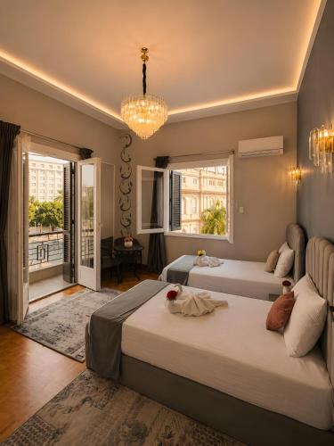 a bedroom with two beds and a chandelier at Garden El Tahrir Downtown Hotel in Cairo