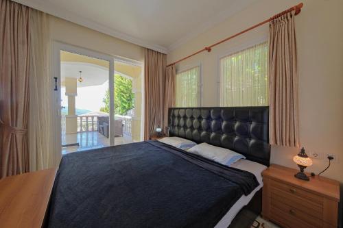 a bedroom with a large bed and a large window at Private Pool Villa with Garden & Forest View in Fethiye
