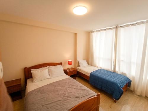 a hotel room with two beds and a window at Hospedaje & Minidepas VALERY in Trujillo