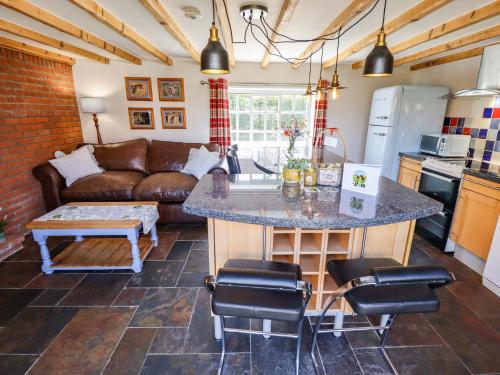 a kitchen and living room with a couch and a table at Gables Cottage in Market Rasen