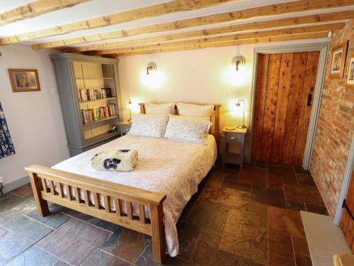 a bedroom with a large bed and a wooden ceiling at Gables Cottage in Market Rasen