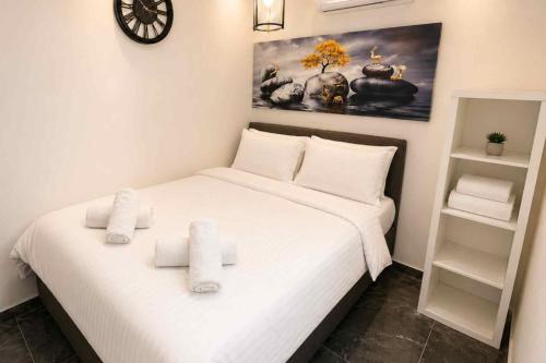 a bedroom with a bed with white sheets and a clock at Barak Royal suites VIP 46 - חמש דקות מהים ומהטיילת in Eilat