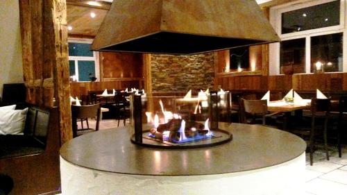a restaurant with a fireplace in the middle of a room at Alte Schmiede in Großbottwar