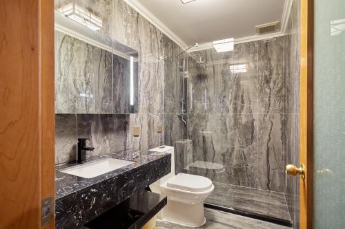 a bathroom with a toilet and a sink and a shower at Beijing Rong Courtyard Boutique Hotel in Beijing