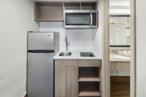 a small kitchen with a sink and a refrigerator at Red Roof Inn & Suites Marysville in Marysville