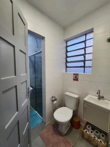 a bathroom with a toilet and a sink at Quarto central em ótima localização in Curitiba