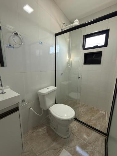 a bathroom with a toilet and a glass shower at Riovale Container Lofts in Petrolina