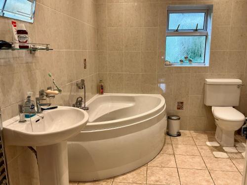 a bathroom with a tub and a sink and a toilet at Home Thyme Holding in Upwell