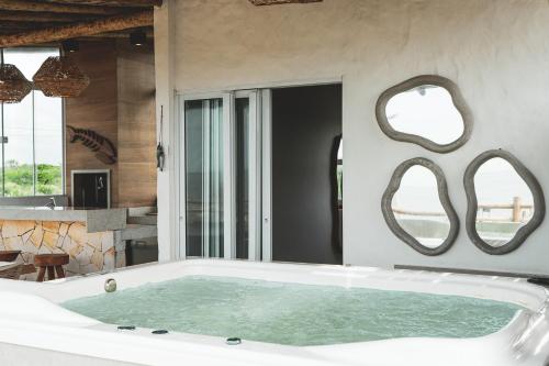 a bathtub in a bathroom with mirrors on the wall at Casa Mandala - Rooftop com Jacuzzi e Vista Mar in Barra Grande