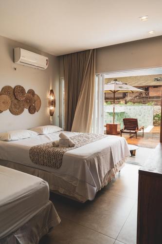 a hotel room with two beds and a balcony at Casa Mandala - Rooftop com Jacuzzi e Vista Mar in Barra Grande