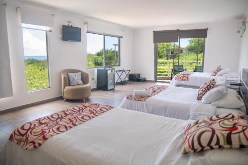 a hotel room with three beds and a television at SeaSide Hotel Galapagos in Puerto Baquerizo Moreno
