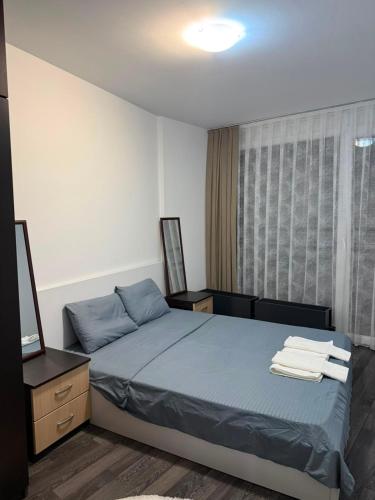 a bedroom with a bed with towels on it at City-Center Space in Mitrovica