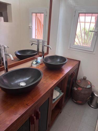 a bathroom with two sinks on a wooden counter at Residence Mangrove Saly in Ngaparou