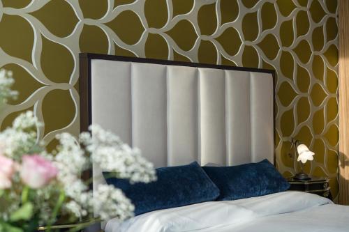 a bed with a white headboard and flowers in a room at Locanda Leon Bianco on the Grand Canal in Venice