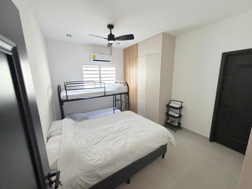 a small bedroom with a bed and a fan at Casa Brisas del Sur in San Juan del Sur
