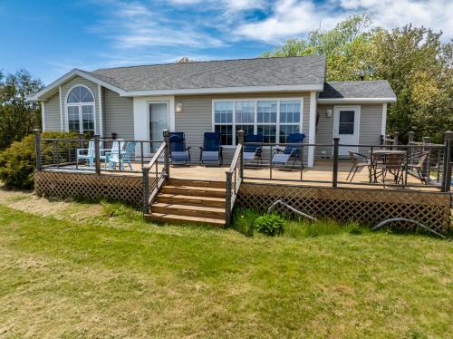 a house with a deck with a table and chairs at Seascape Serenity with Epic Coastal Views! in Lubec