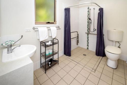 a bathroom with a toilet and a sink and a shower at Big4 Sydney Lakeside Holiday Park in Narrabeen