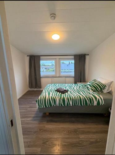 a bedroom with a bed with a green and white comforter at Four bedroom house close to the beach in Abbekås