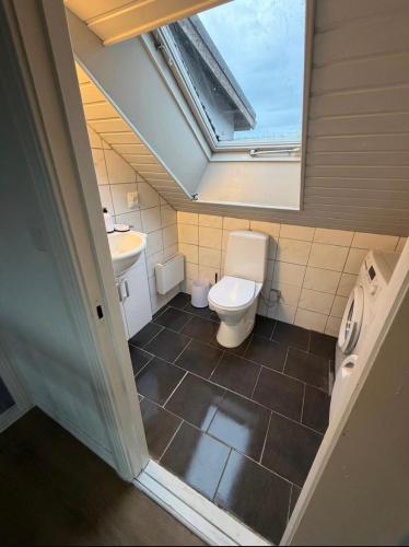 a bathroom with a toilet and a sink and a skylight at Four bedroom house close to the beach in Abbekås