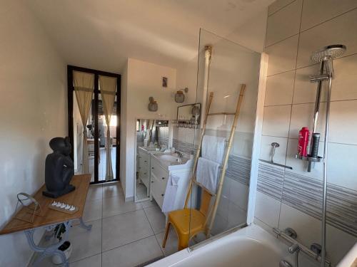 a bathroom with a tub and a sink at L'appartement du bonheur - Au Cœur des Volcans d'Auvergne sur la Route du Sud in Issoire