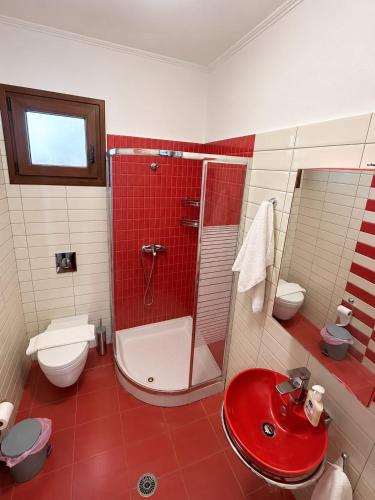 ein Badezimmer mit rotem Waschbecken und Dusche in der Unterkunft Amaya Pine Central in Chrysoupolis