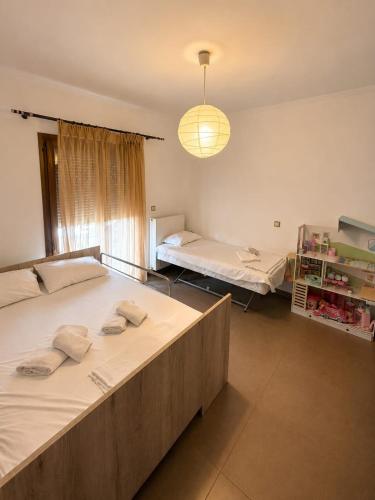 ein Schlafzimmer mit zwei Betten und einer Hängelampe in der Unterkunft Amaya Pine Central in Chrysoupolis