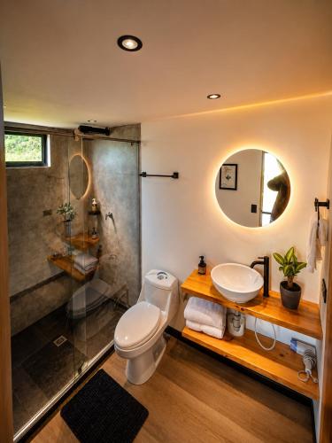 a bathroom with a shower and a toilet and a sink at Basecamp Colombia in Carmen de Carupa