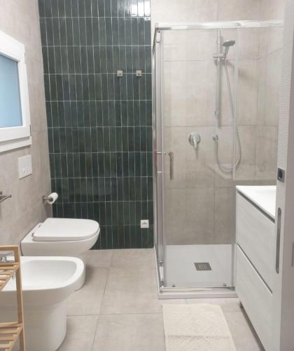 a bathroom with a shower and a toilet and a sink at Room via Florio in Alcamo
