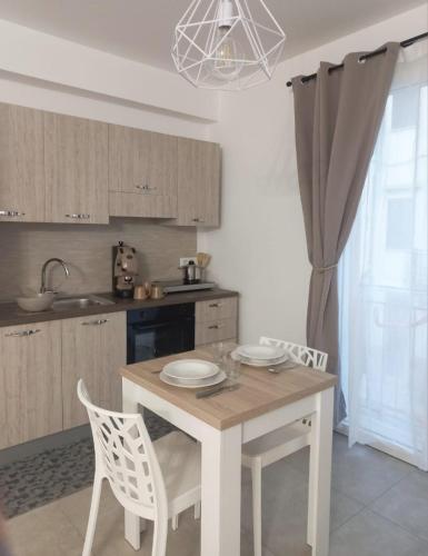 a kitchen with a table and two chairs and a kitchen with a sink at Room via Florio in Alcamo