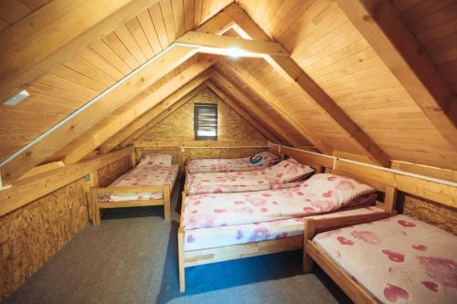 a room with two beds in a attic at Vikendica Na Plivi E&M in Šipovo
