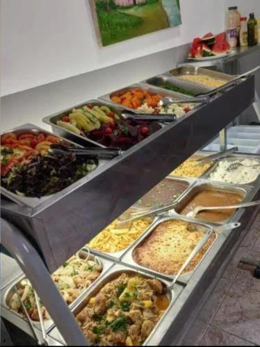 a buffet filled with lots of different types of food at Pousada Alphaville in Aparecida