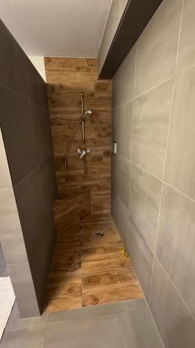 a bathroom with a shower with a wooden wall at Ferienwohnung Emerson 2 in Edemissen