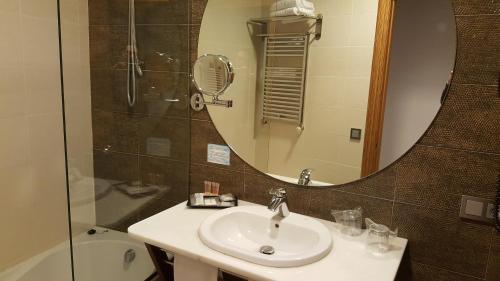 a bathroom with a sink and a mirror at Cumbria Spa Hotel 3* Sup in Ciudad Real